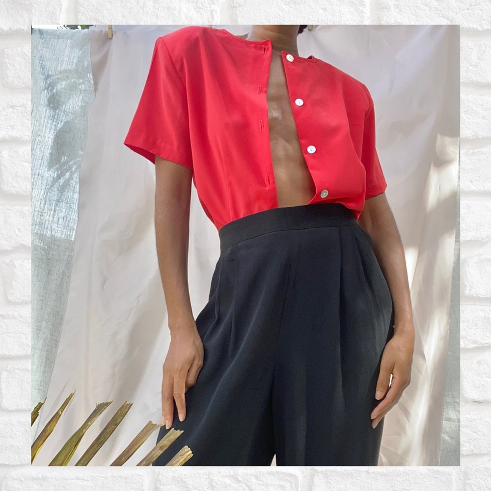 Red buttoned blouse with shoulder pads.
